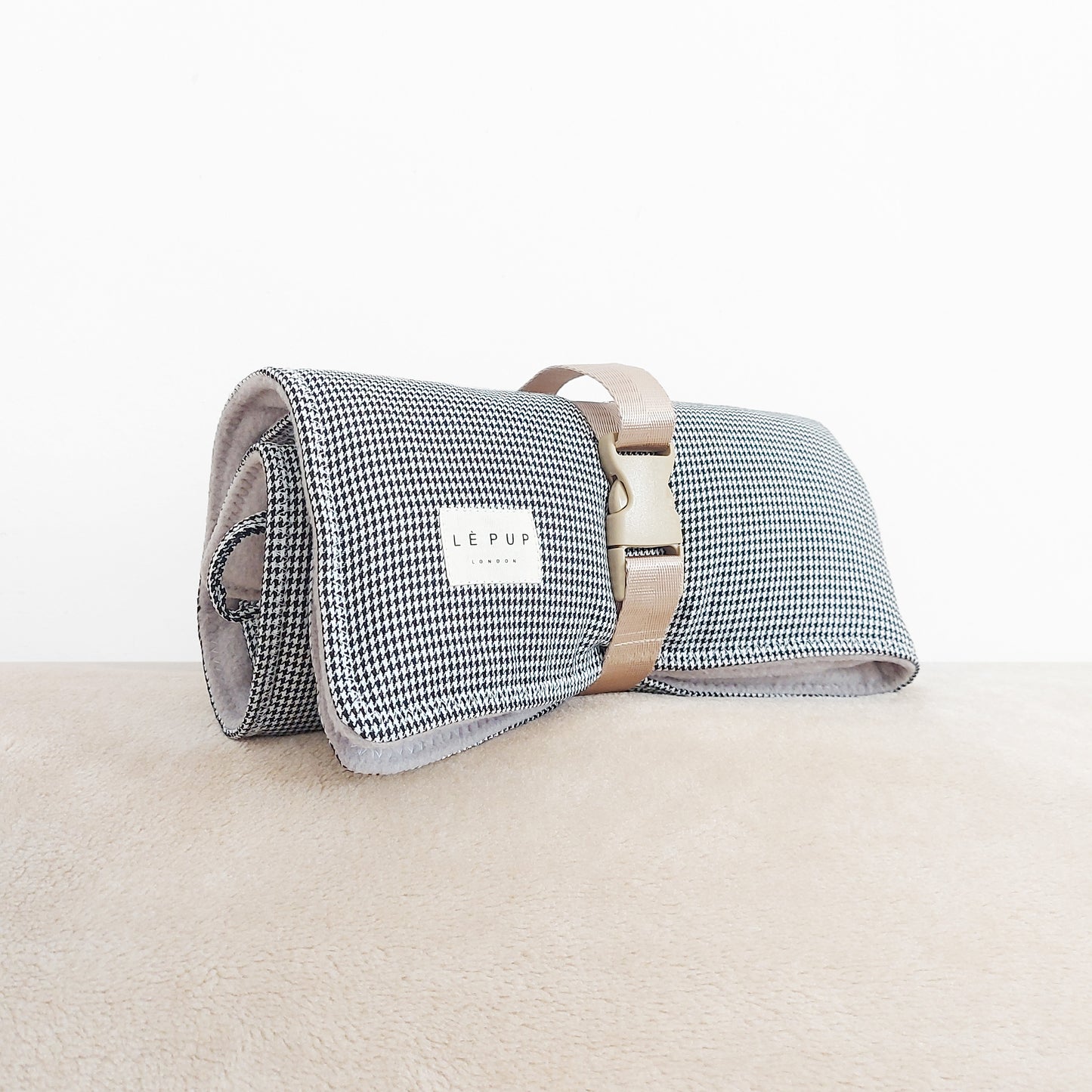 Side view of rolled up dogtooth dog travel mat by LE PUP.