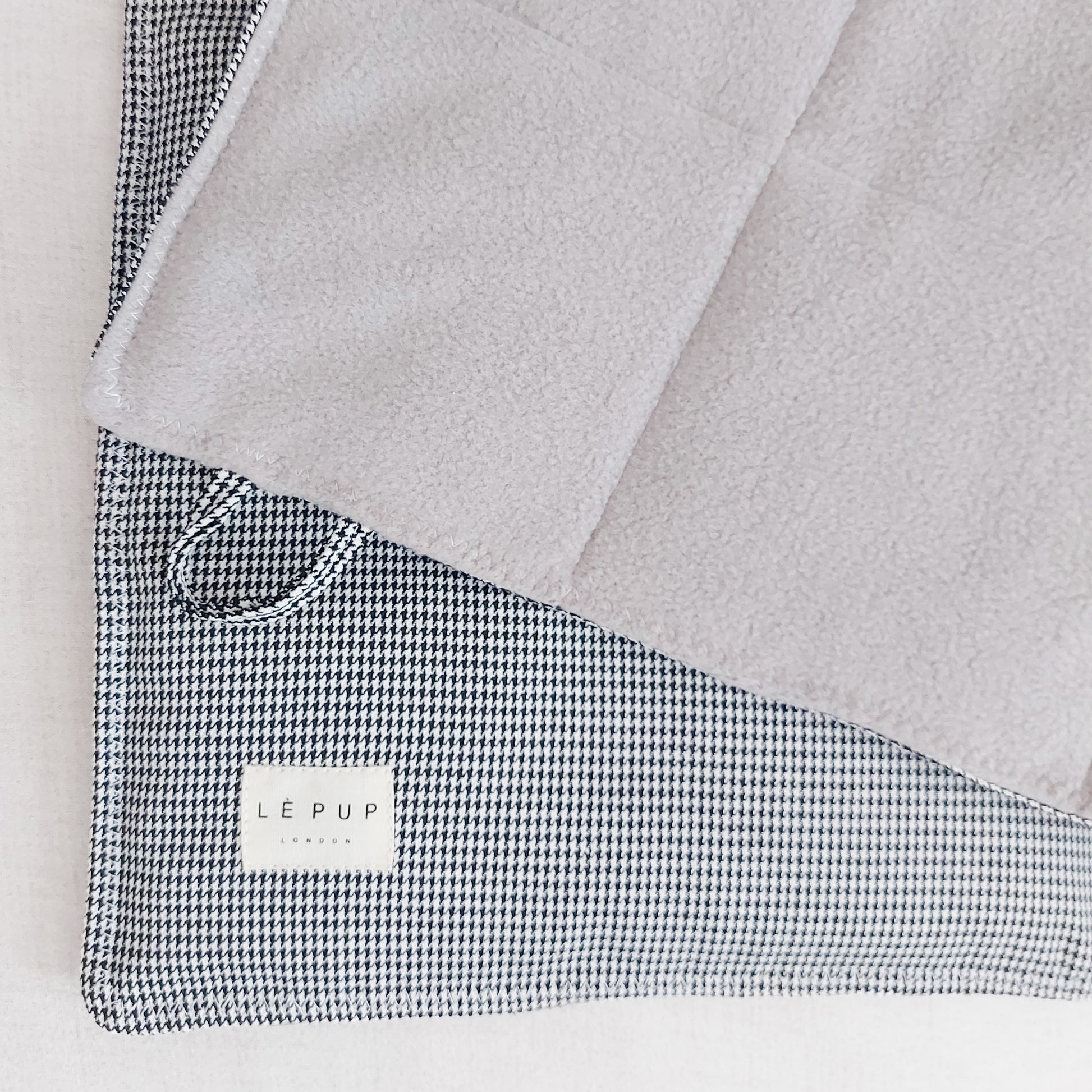 Reversible dog travel mat featuring quilted fleece for comfort and houndstooth fabric for style by LE PUP.